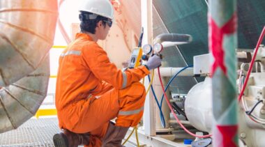 Photo of refrigeration engineer examining pipework