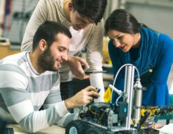 Photo of robotics engineers examining robot parts