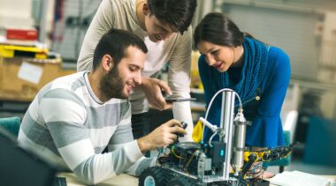 Photo of robotics engineers examining robot parts