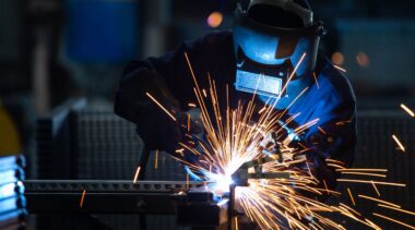 Photo of sheet metalworker in protective gear using power tool