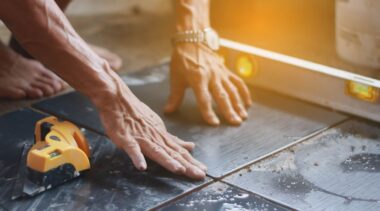 Photo of tiler placing tile on floor with spirit level