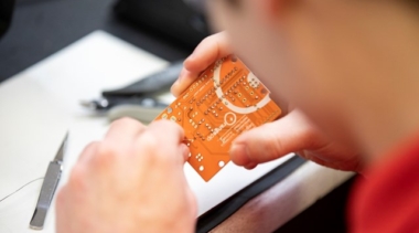 young student holding circuit board
