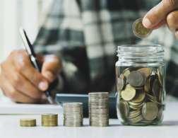 Coins being counted into a glass jar