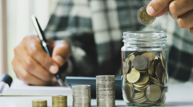 Coins being counted into a glass jar