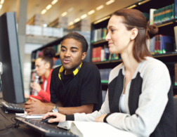 Young man and woman looking at computer screen