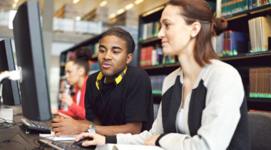 Young man and woman looking at computer screen