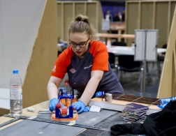 Female tiling competitor cutting tiles