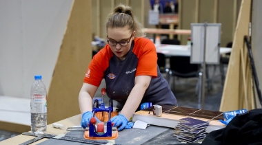 Female tiling competitor cutting tiles