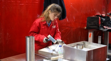 Female competitor hammering metal