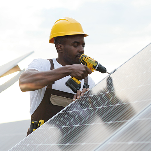 young man fixing solar panels on roof