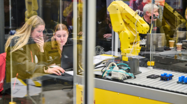 Two industrial robotics students working on a project