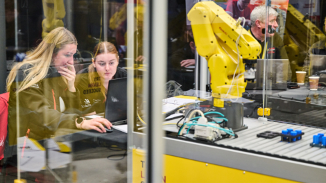 Two industrial robotics students working on a project