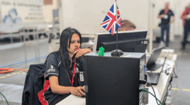 Female competitor focused on computer in engineering competition environment