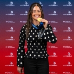 Female gold medal winner in electrical installation 2025 with medal in hand with WorldSkills UK backdrop