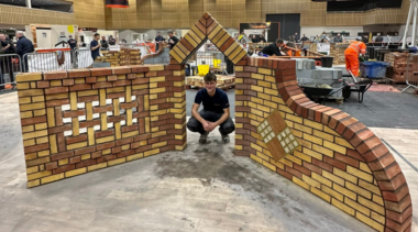 Bricklaying competitor posing in front of his work